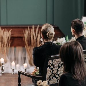 People sitting in a church looking at a casket at a funeral