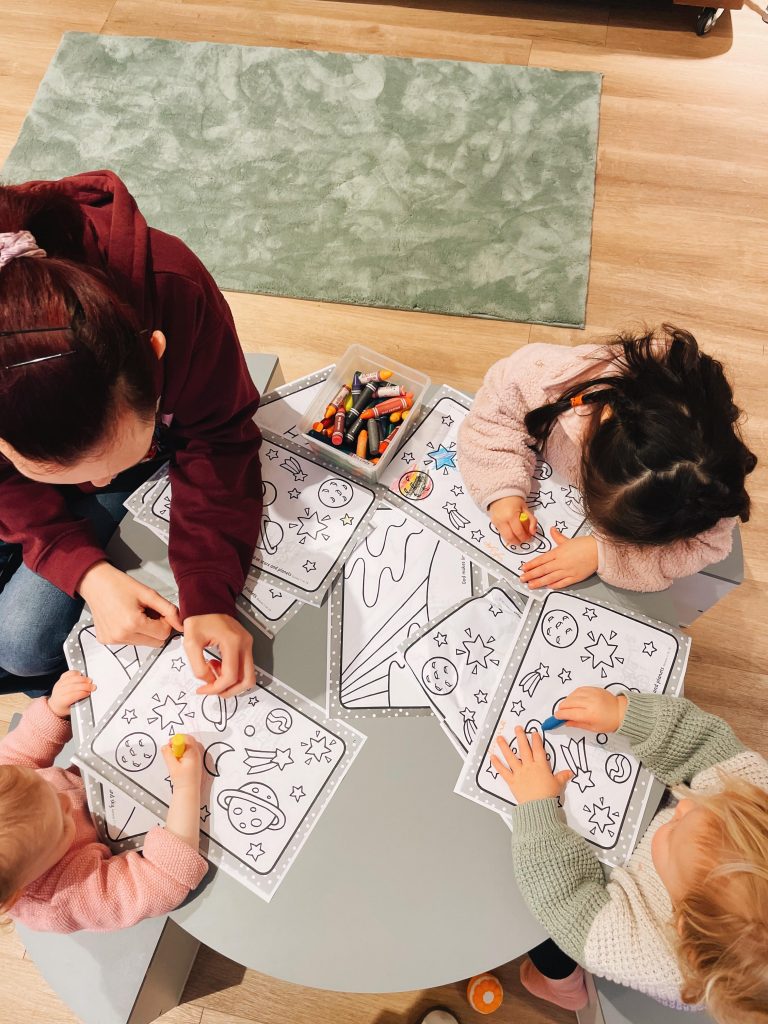 kids sitting at a table drawing
